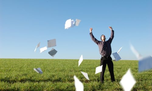 A happy businessman letting go of paperwork